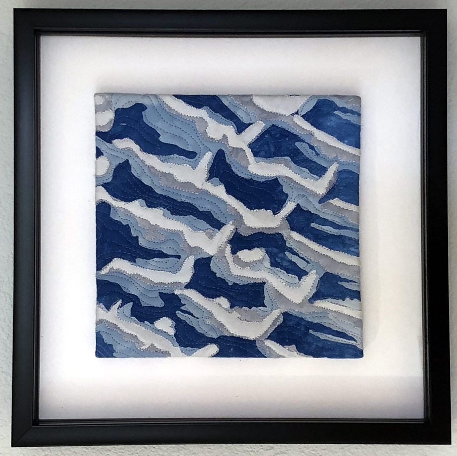 Framed collaged art quilt of tire tracks in snow