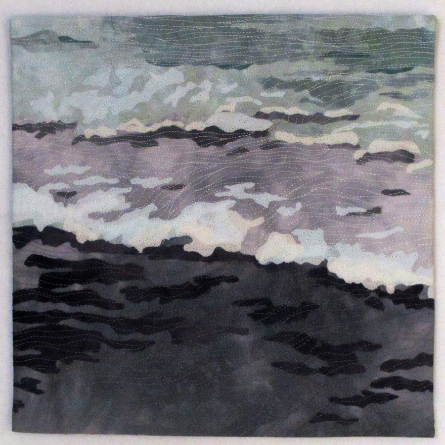 Collaged art quilt of ocean beach at dusk