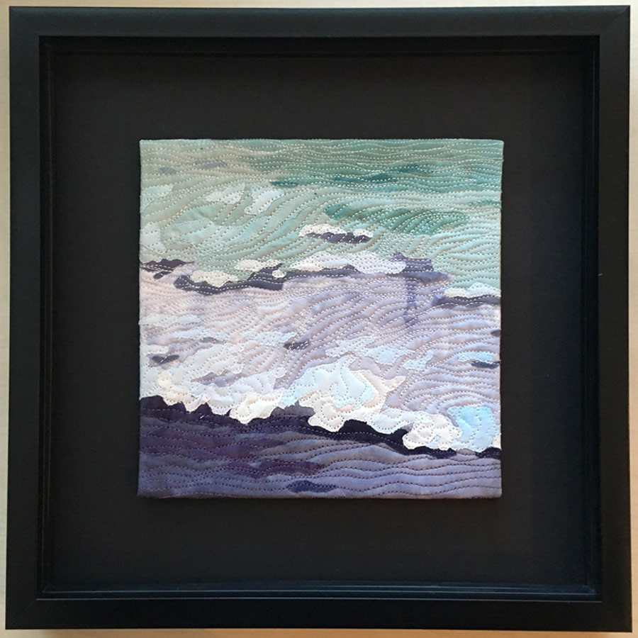 Collaged art quilt of ocean beach at dusk